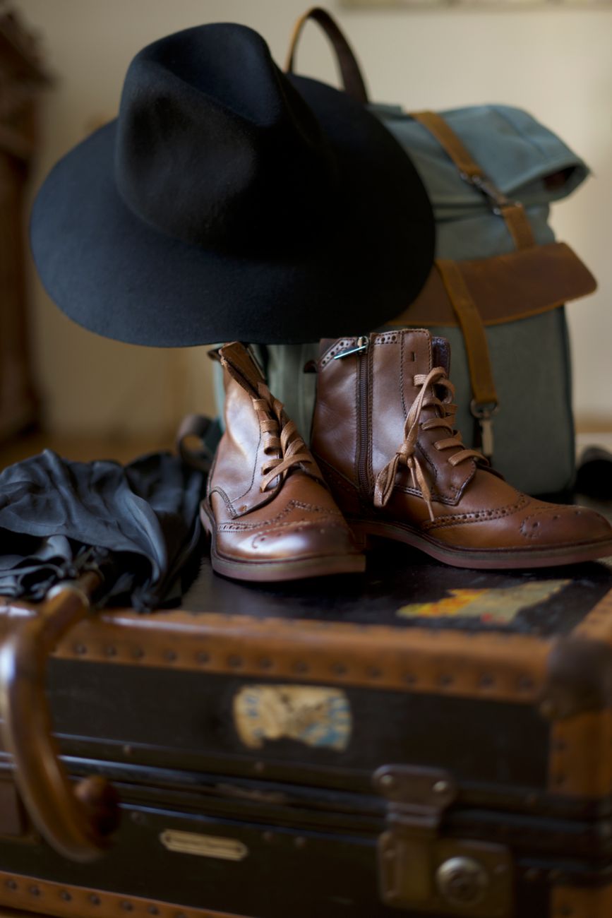 Curated travel luggage with wool garments and leather notebook